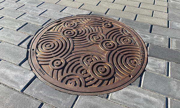 Decorative cast iron manhole cover in Oblio pattern