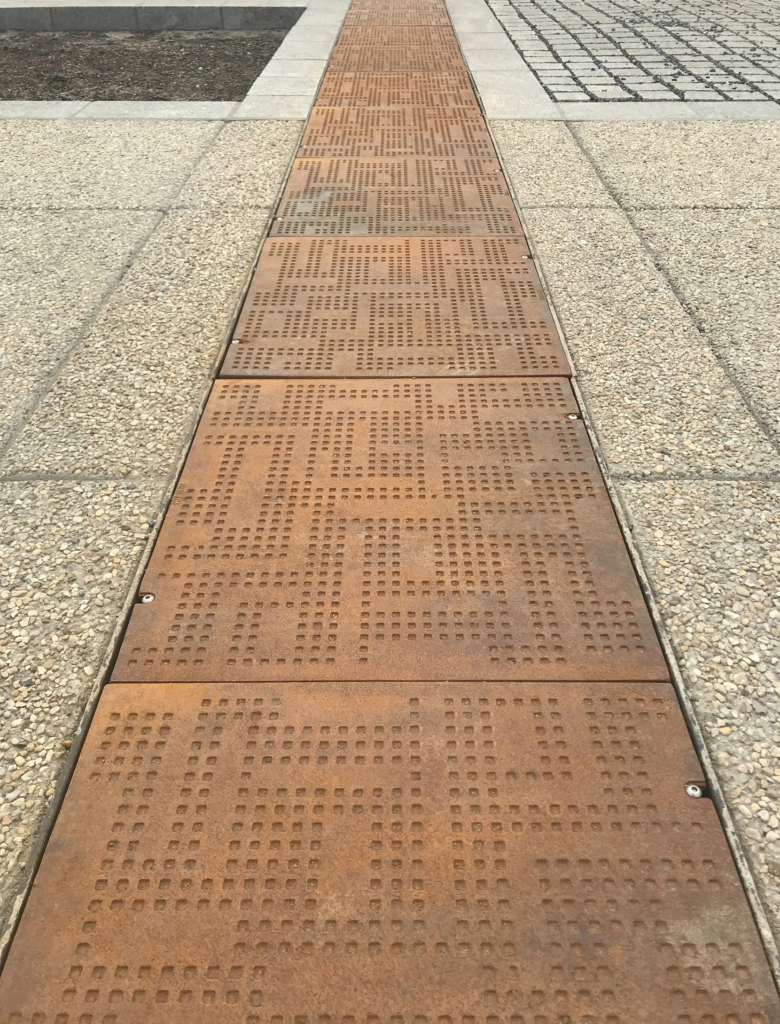 Cast iron solid utility cover with modern Urban Rhythms pattern.