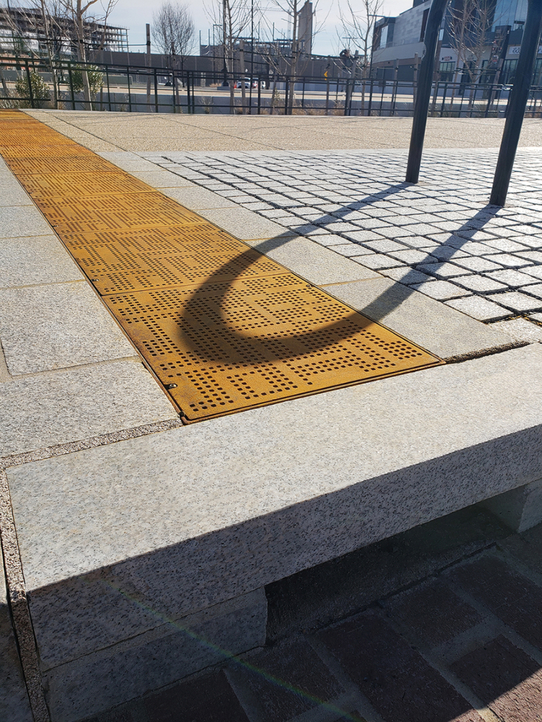 Cast iron solid utility cover with modern Urban Rhythms pattern.