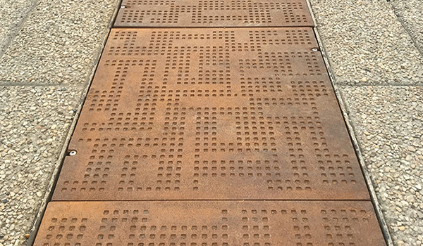 Cast iron solid utility cover with modern Urban Rhythms pattern.