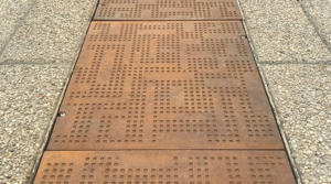 Cast iron solid utility cover with modern Urban Rhythms pattern.