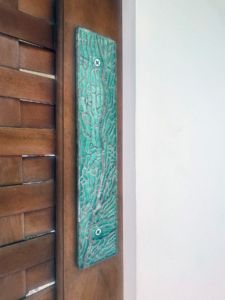 Coral patterned door push plate in cast bronze with tiffany blue patina.