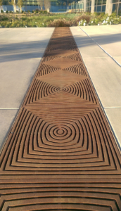 Cast iron grate in decorative Divisadero pattern by Iron Age Designs. Arrayed as bioswale inlet grates.