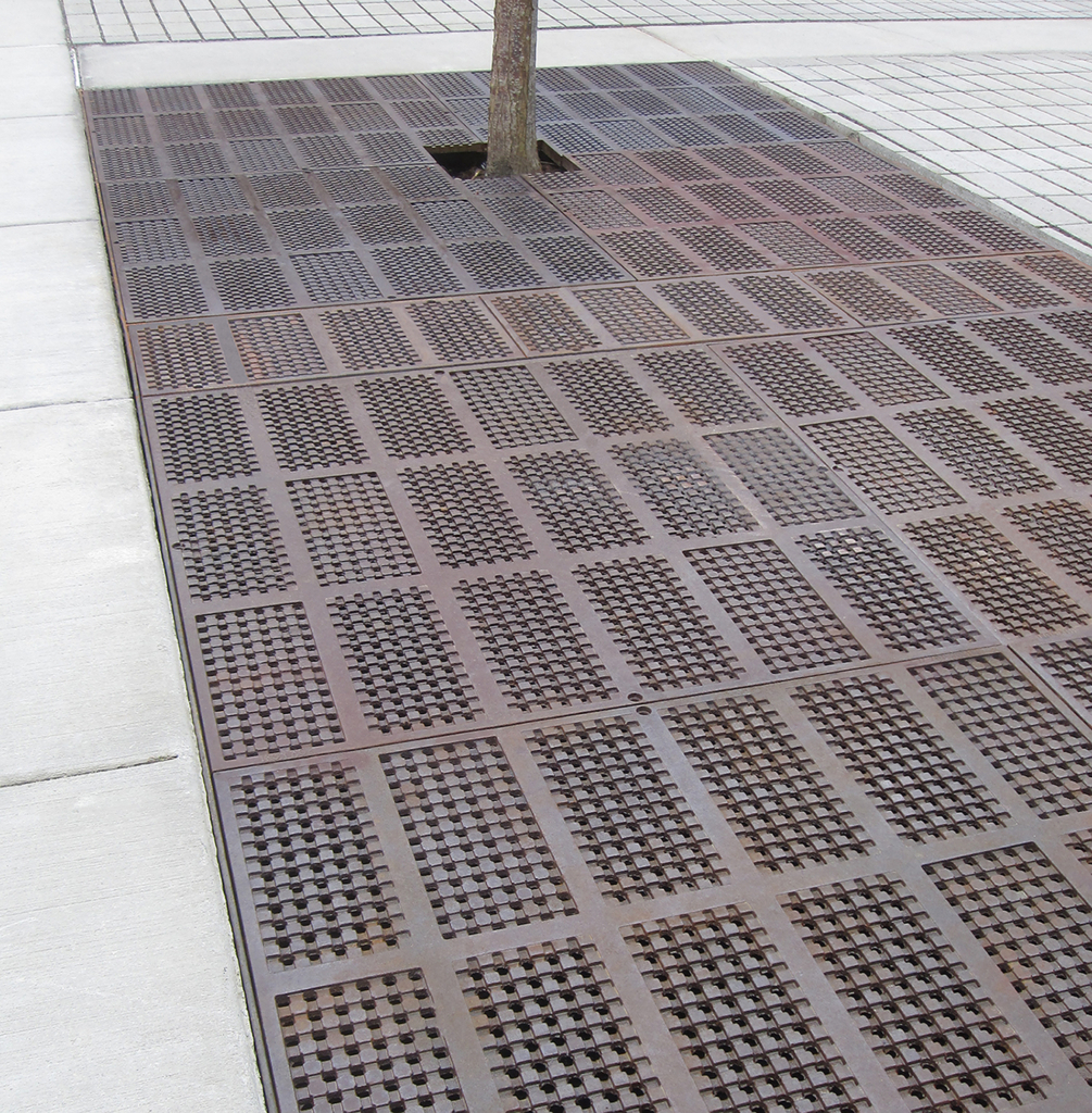 Cast iron grate panel in decorative Explora pattern by Iron Age Designs, Arrayed as a large tree grate.
