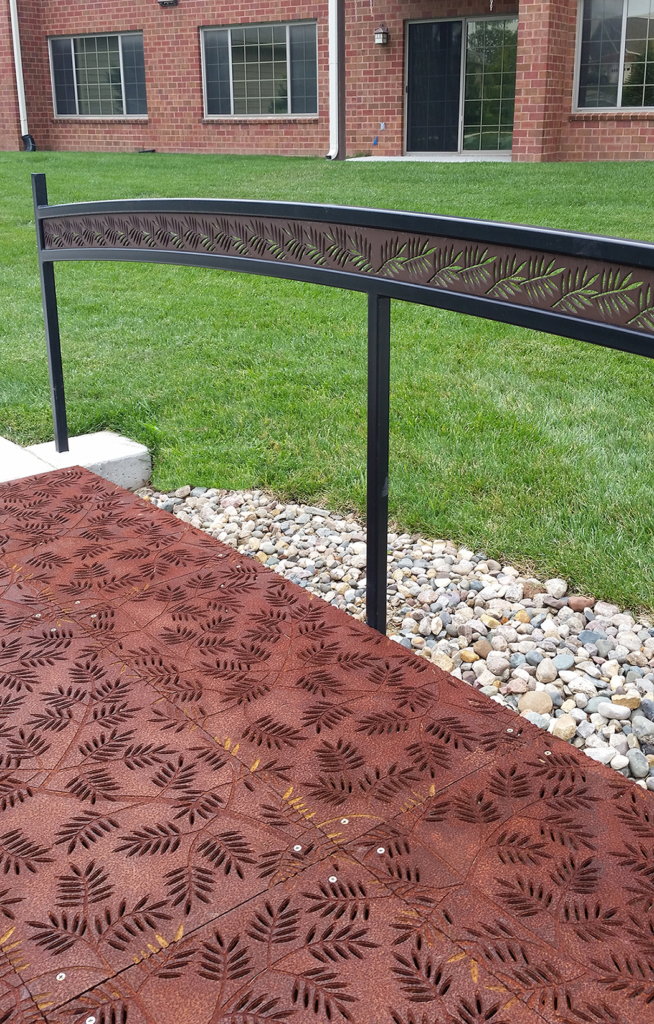 Cast iron grates in decorative Locust pattern by Iron Age Designs. Arrayed as a pedestrian bridge with matching laser cut handrail.