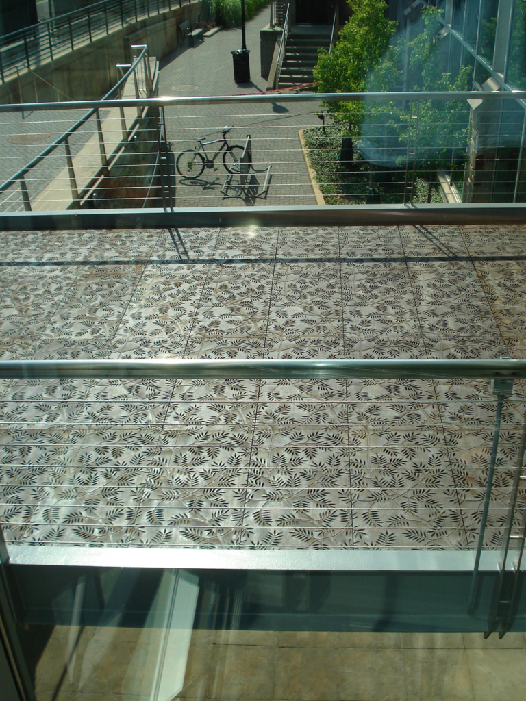 Cast iron grates in decorative Locust pattern by Iron Age Designs. Arrayed as a pedestrian bridge deck.