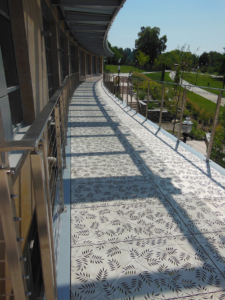 Cast aluminum grates in decorative Locust pattern by Iron Age Designs. Arrayed as a pedestrian bridge deck.