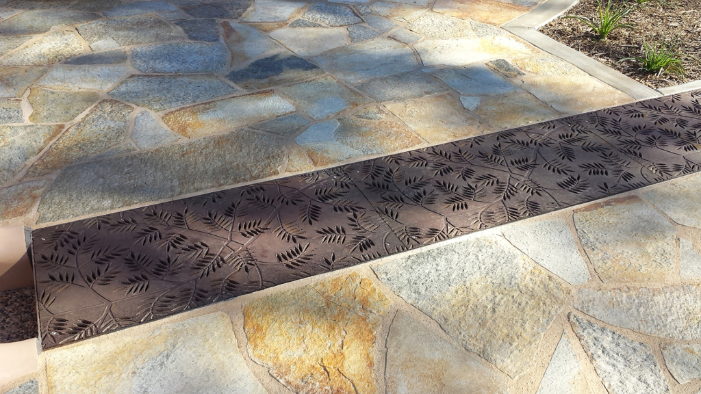 Cast iron grates in decorative Locust pattern by Iron Age Designs. Arrayed as a pedestrian bridge.