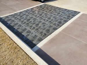 Cast iron grates in decorative Oblio pattern by Iron Age Designs. Arrayed as large stormwater inlet.