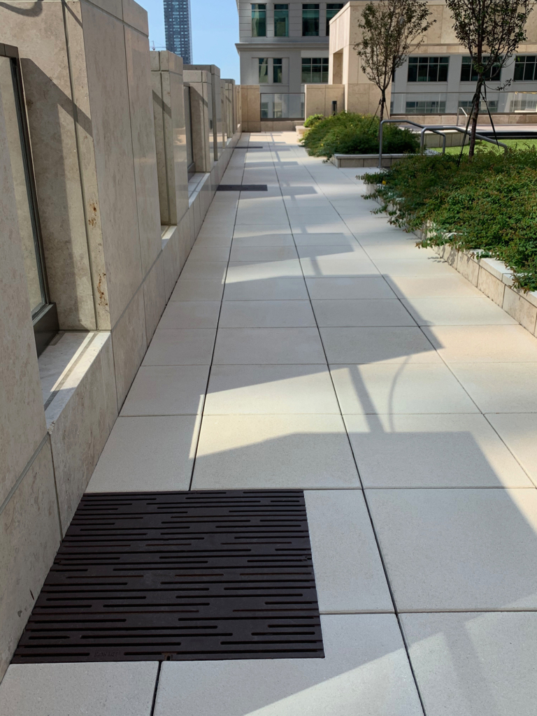 Cast iron grate in decorative Rain pattern by Iron Age Designs. Baked-on-oil finish. Rooftop deck installation.