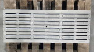Cast iron drain grate with wayfinding directional bars. In Que pattern by Iron Age Designs.