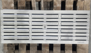 Cast iron drain grate with wayfinding directional bars. In Que pattern by Iron Age Designs.