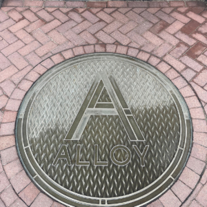 Cast bronze plaque with "A" in front of entryway to Alloy Apartments