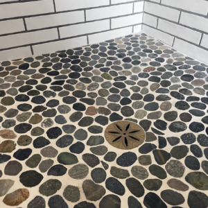 Decorative cast bronze shower drain grate featuring Anise star pattern.