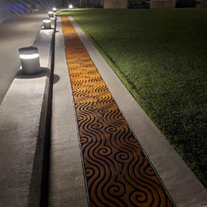 Decorative cast iron trench grates with rolling wave Argo pattern.