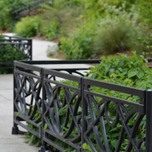 Decorative cast iron planter fence in Belle pattern with black powder coat finish.