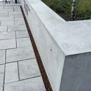 Decorative cast iron trench grate in Carbochon pattern, installed in pavers.