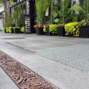 Decorative cast iron trench grates featuring interlocking gear pattern