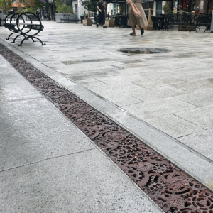 Decorative cast iron trench grates featuring interlocking gear pattern