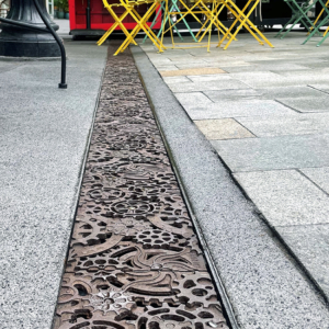 Decorative cast iron trench grates featuring interlocking gear pattern