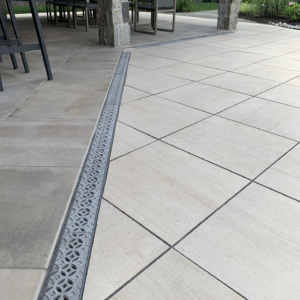 Decorative cast aluminum trench grates with Interlaken pattern installed in pool patio