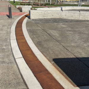 Cast iron trench grate with rounded edge holes in a grid pattern.