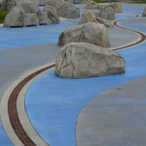 Decorative cast iron radius trench grates installed in spray park
