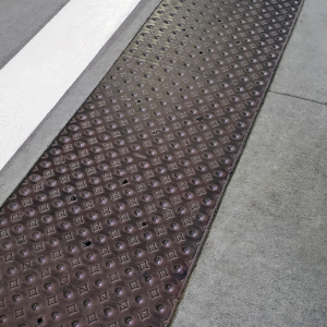 Decorative cast iron detectable warning plate in Interlaken pattern