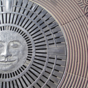 Decorative cast bronze catch basin with moon face design