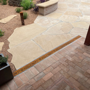 Decorative cast iron trench grate installed in paver patio