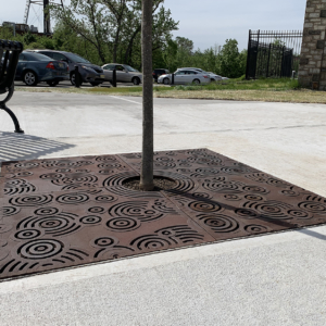 Cast iron tree grate in Oblio pattern which suggests circular ripples on water