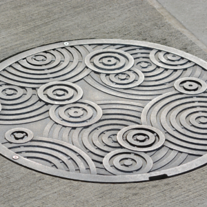 Decorative cast aluminum manhole cover in Oblio pattern