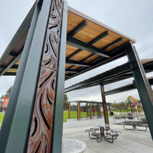 Decorative trench grates installed over pergola downspouts and in ground plane