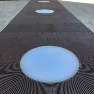 Cast iron grates surrounding LED lights, all installed in a pedestrian plaza