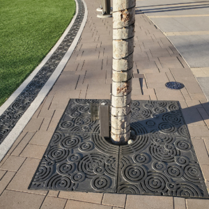 Cast iron radius trench grates and tree grate in Oblio pattern which suggests circular ripples on water