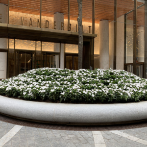 Decorative cast bronze radius trench grates in Que pattern surrounding circular planter in front of One Vanderbilt building