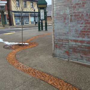 Decorative cast iron radius trench grates with Locust pattern