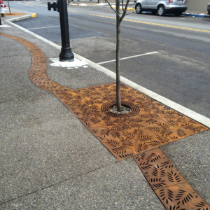 Decorative cast iron radius trench grates with Locust pattern