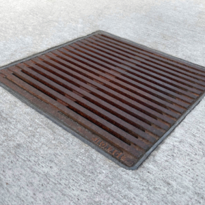 Decorative cast iron catch basin grate in Regular Joe pattern