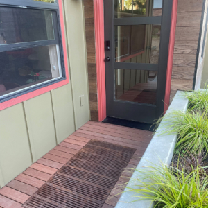 Decorative cast iron catch basin grate in Regular Joe pattern, installed as a walk off mat in front of a residential entryway