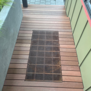 Decorative cast iron catch basin grate in Regular Joe pattern, installed as a walk off mat in front of a residential entryway