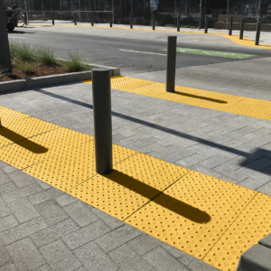 Cast iron detectable warning plate with decorative Interlaken design and yellow powder coat finish.