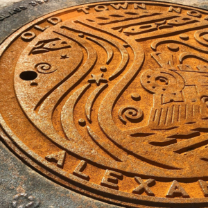 Raw cast iron plaque for Old Town North, Alexandria, VA with a train motif celebrating the city's transportation history