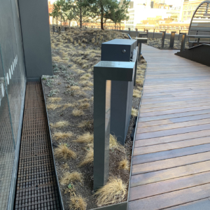 Cast iron trench drain grate in linear Plex pattern. Shown in rooftop garden.