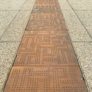 Cast iron solid utility cover with modern Urban Rhythms pattern.